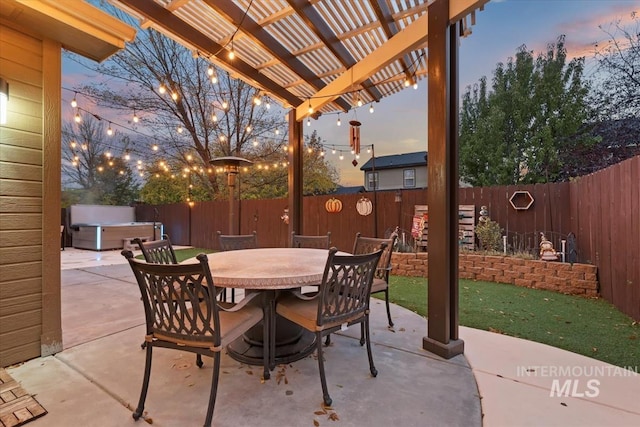 patio terrace at dusk featuring a pergola and a hot tub