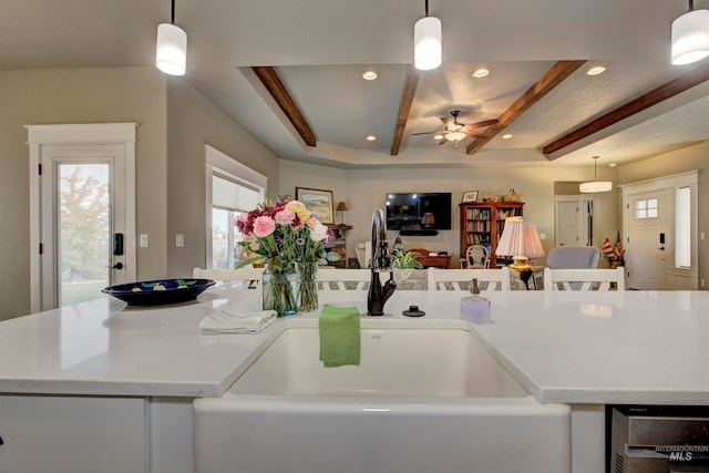 kitchen with ceiling fan, beverage cooler, sink, and hanging light fixtures