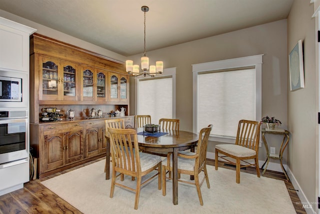 dining area with a chandelier and wood-type flooring