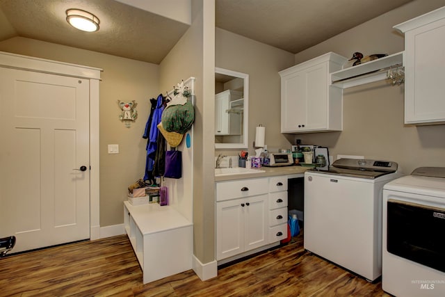 laundry room featuring sink, cabinets, washer and clothes dryer, and dark hardwood / wood-style floors