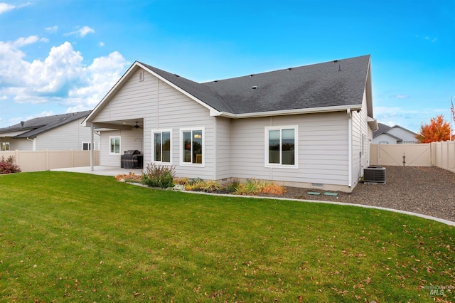 rear view of property with a patio, central AC, and a yard