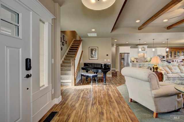 living room with hardwood / wood-style floors and beam ceiling