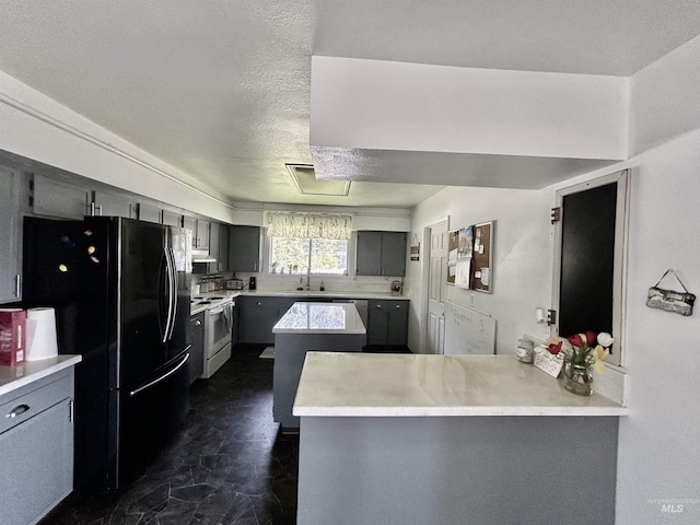 170 Red Fir Rd, Kooskia, ID 83539 - kitchen with white electric stove, gray cabinetry, and freestanding refrigerator