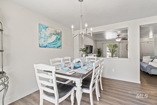 4249 W Farlam Dr, Meridian, ID 83642 - dining room with baseboards, wood finished floors, a chandelier, and a ceiling fan