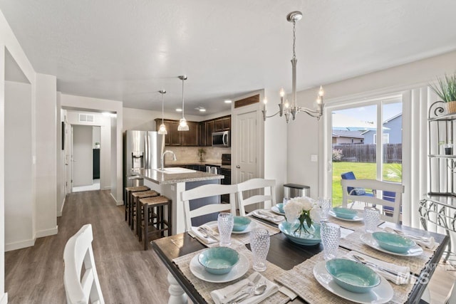 4249 W Farlam Dr, Meridian, ID 83642 - dining area with wood finished floors, a chandelier, and baseboards