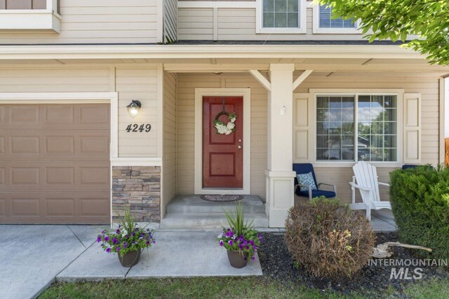 4249 W Farlam Dr, Meridian, ID 83642 - view of exterior entry featuring an attached garage, stone siding, and a porch