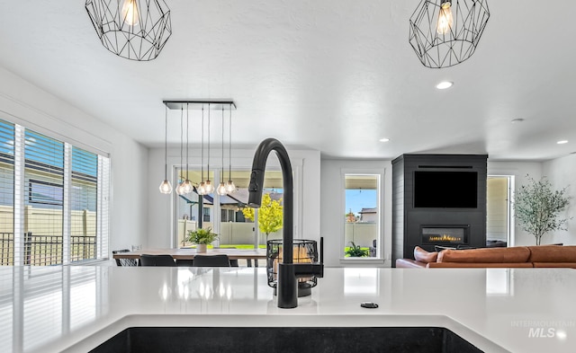2398 N Klemmer Ave, Kuna, ID 83634 - detailed view of a chandelier, a large fireplace, recessed lighting, light countertops, and pendant lighting