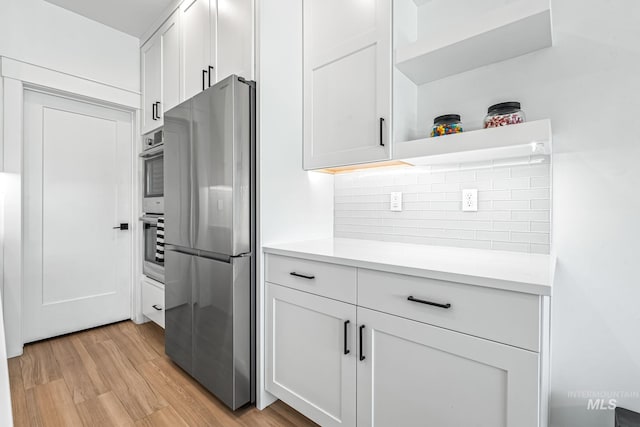 2398 N Klemmer Ave, Kuna, ID 83634 - kitchen featuring freestanding refrigerator, light wood-type flooring, decorative backsplash, and light countertops