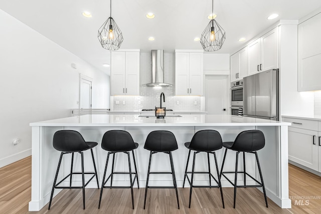 2398 N Klemmer Ave, Kuna, ID 83634 - kitchen with wall chimney range hood, appliances with stainless steel finishes, tasteful backsplash, recessed lighting, and light wood finished floors