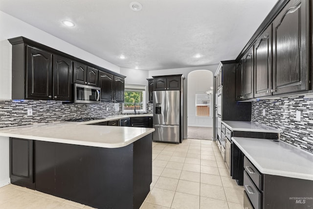 1992 S Elkhound Ave, Meridian, ID 83642 - kitchen with stainless steel appliances, a peninsula, light countertops, tasteful backsplash, and light tile patterned floors