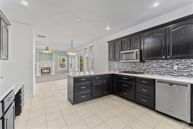 1992 S Elkhound Ave, Meridian, ID 83642 - kitchen with stainless steel appliances, light countertops, ceiling fan, dark cabinets, and decorative backsplash