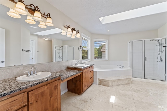 1992 S Elkhound Ave, Meridian, ID 83642 - bathroom featuring a skylight, double vanity, a shower stall, a garden tub, and tile patterned flooring