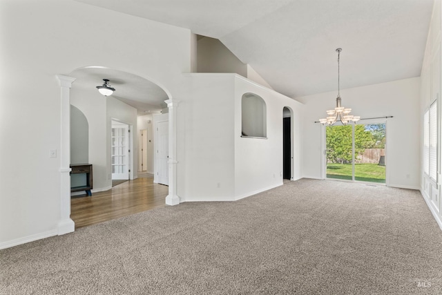 1992 S Elkhound Ave, Meridian, ID 83642 - carpeted empty room with high vaulted ceiling, arched walkways, a chandelier, baseboards, and ornate columns