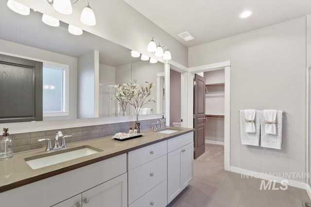 bathroom featuring vanity, backsplash, and tile patterned flooring