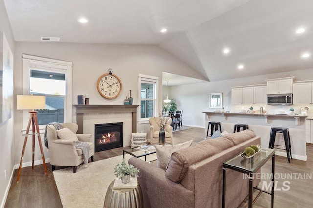 living room featuring hardwood / wood-style flooring, a wealth of natural light, and vaulted ceiling