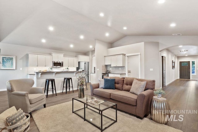 living room featuring vaulted ceiling and light hardwood / wood-style flooring