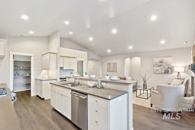 kitchen with white cabinetry, a kitchen island with sink, wood-type flooring, vaulted ceiling, and stainless steel appliances