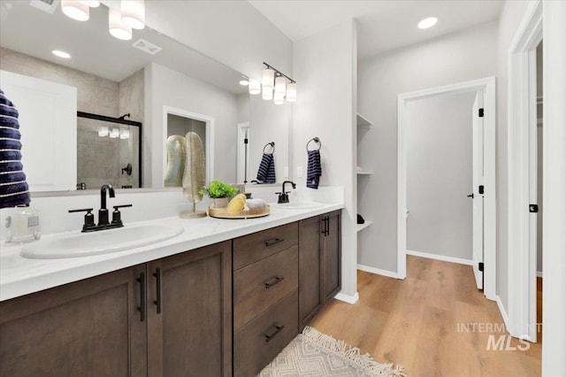 bathroom featuring vanity, an enclosed shower, and hardwood / wood-style floors