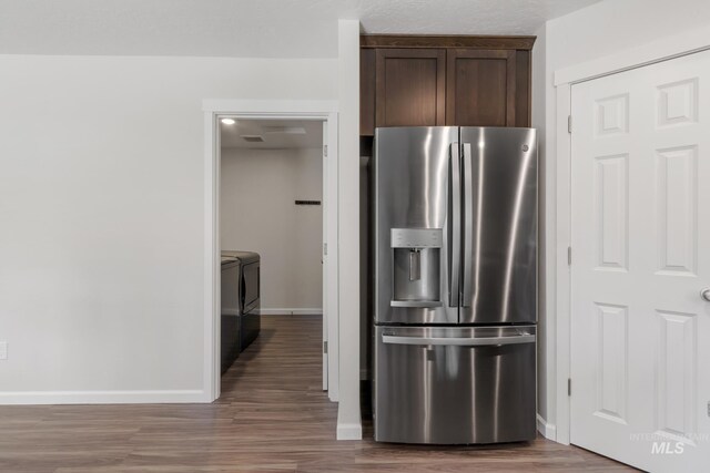 207 Lainey Ln, Idaho City, ID 83631 - kitchen featuring stainless steel fridge, dark brown cabinetry, washer and clothes dryer, and wood finished floors
