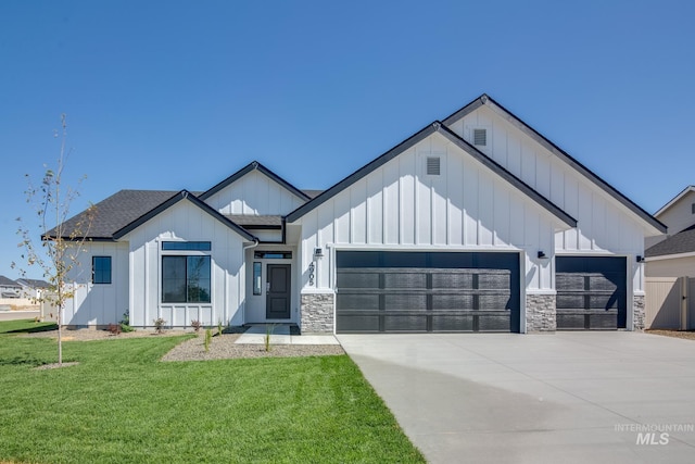 modern farmhouse style home with a shingled roof, board and batten siding, a front yard, a garage, and driveway