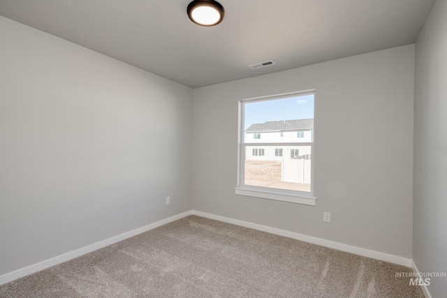 unfurnished room featuring carpet, visible vents, and baseboards