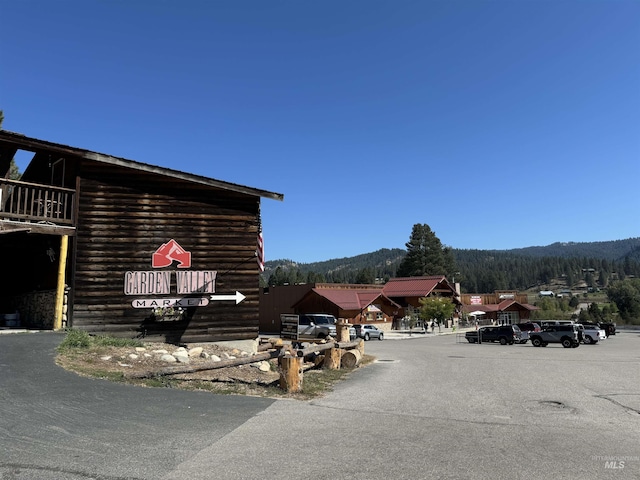 view of side of home with a mountain view and uncovered parking