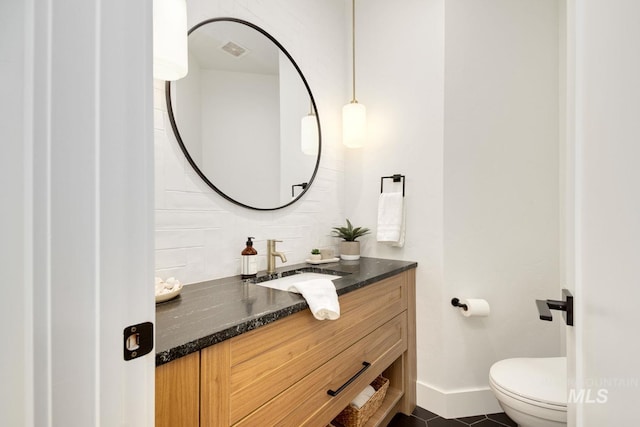 bathroom featuring tile patterned floors, vanity, and toilet