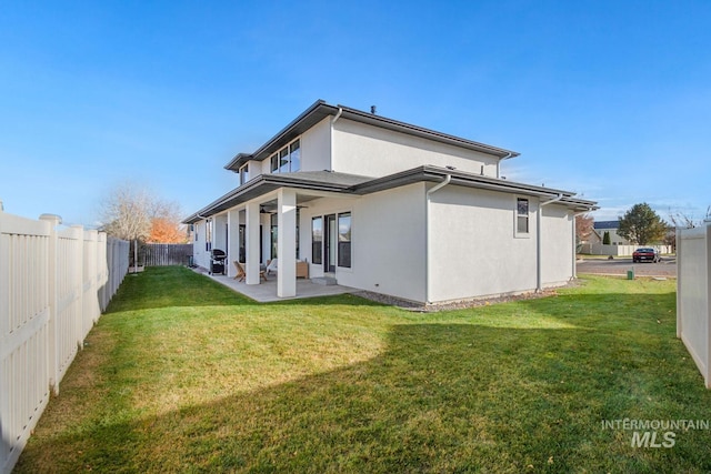 back of property featuring a lawn and a patio