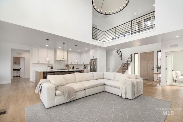 living room with a high ceiling and light wood-type flooring