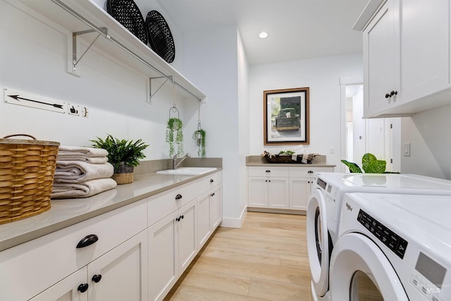 washroom featuring washer and dryer, cabinet space, light wood finished floors, and recessed lighting