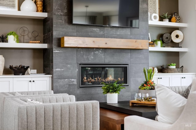 living room featuring a tiled fireplace