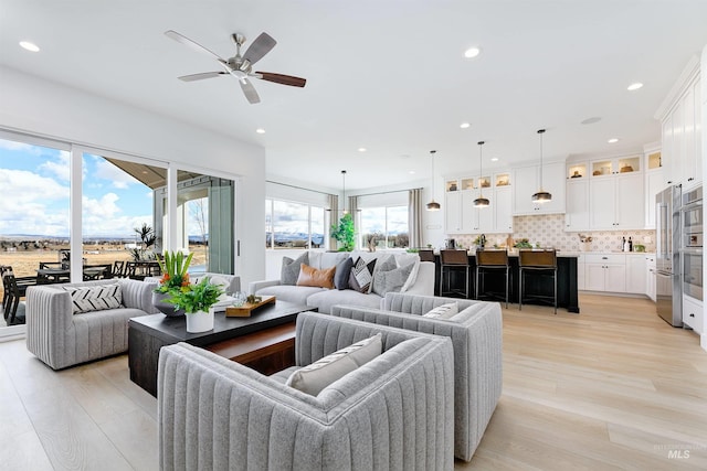 living area featuring a ceiling fan, light wood-style flooring, and recessed lighting