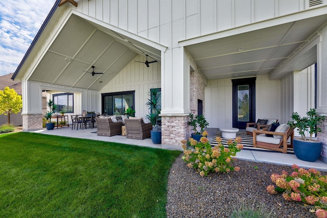 back of house featuring outdoor lounge area, board and batten siding, and a yard