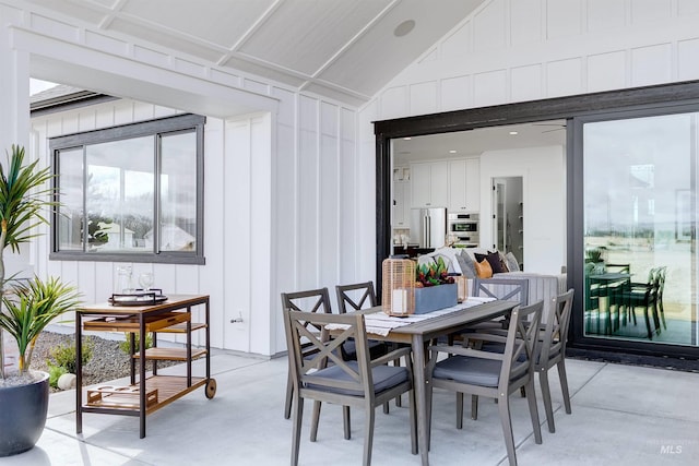 dining room featuring concrete flooring and vaulted ceiling
