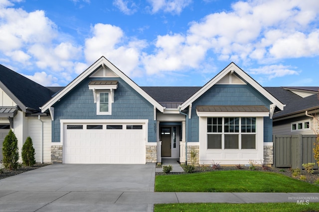 craftsman-style home featuring a front yard, a standing seam roof, driveway, and metal roof