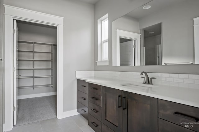 bathroom featuring tile patterned flooring, vanity, and baseboards