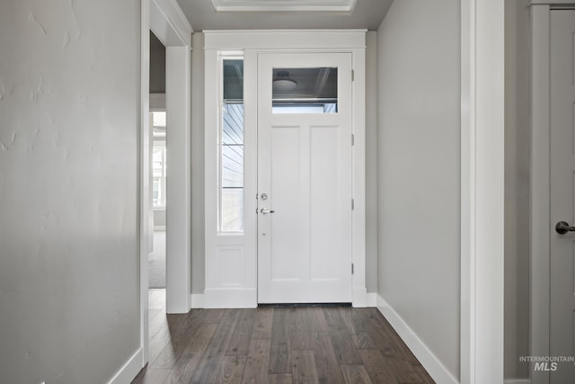 foyer featuring baseboards and dark wood-type flooring