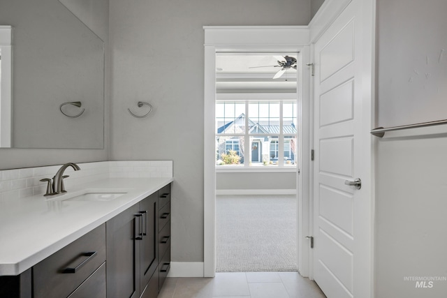 bathroom with baseboards, vanity, and a ceiling fan