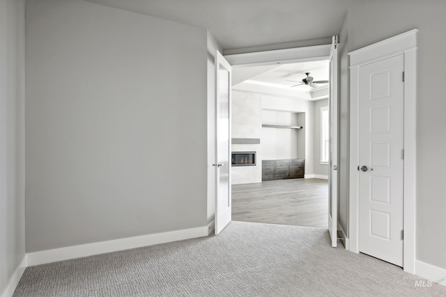 interior space featuring a ceiling fan, a fireplace, and baseboards