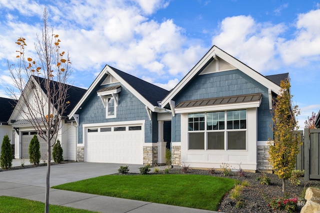 craftsman house featuring metal roof, concrete driveway, stone siding, a standing seam roof, and a front yard