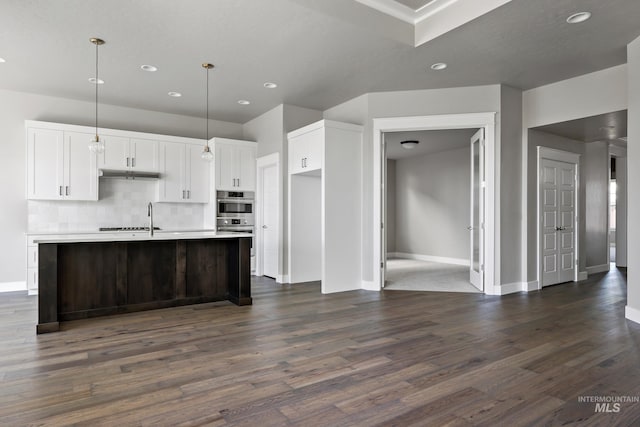 kitchen with dark wood-style flooring, light countertops, backsplash, white cabinetry, and baseboards