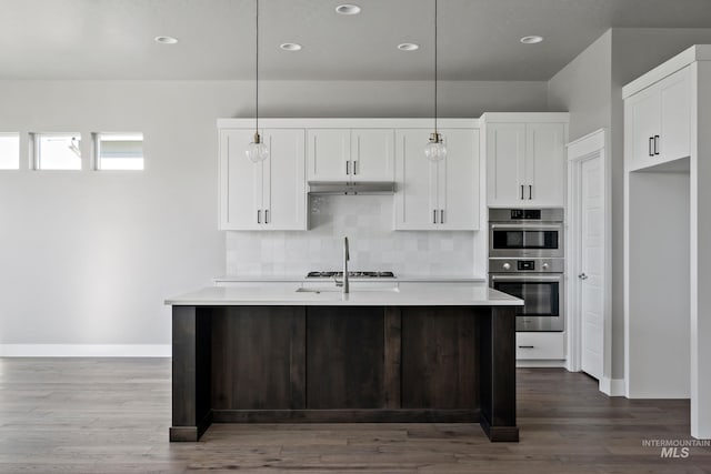 kitchen with white cabinetry, stainless steel double oven, light countertops, and backsplash