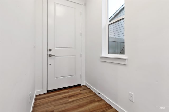 doorway to outside with baseboards and wood finished floors