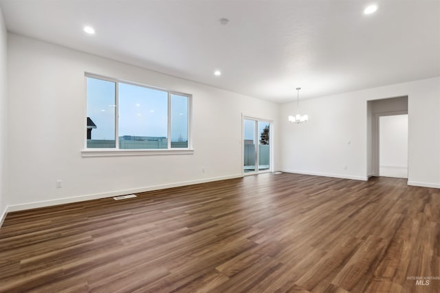 unfurnished room with dark wood-type flooring, a notable chandelier, and recessed lighting