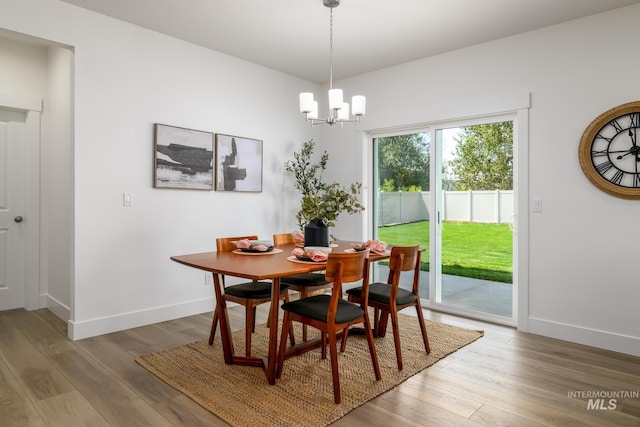 dining room with light hardwood / wood-style flooring and a chandelier