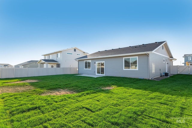 rear view of house featuring central AC unit, a yard, a fenced backyard, and a patio