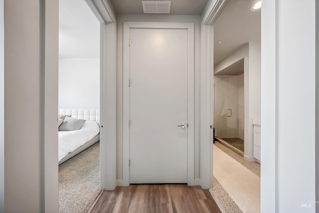 hallway with visible vents and wood finished floors