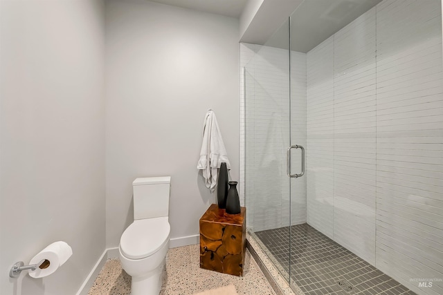 full bath featuring a stall shower, toilet, speckled floor, and baseboards