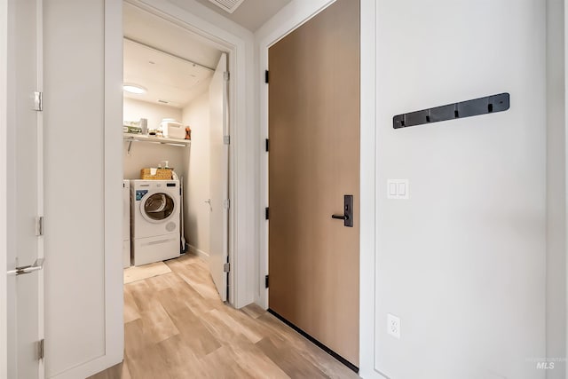 hallway with light wood-style flooring and washing machine and dryer