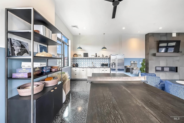 kitchen featuring visible vents, a large fireplace, stainless steel refrigerator with ice dispenser, white cabinets, and open shelves